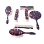 A group of early 20th century silver mounted brushes and a hand mirror.