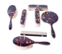 A group of early 20th century silver mounted brushes and a hand mirror.