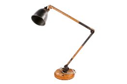 A vintage industrial adjustable workshop lamp. Raised on a heavy circular metal base.