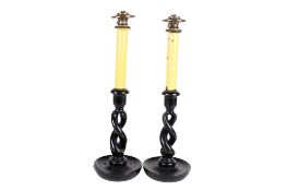 A pair of oil lamps modelled as candlesticks. With ebonized twist bases.