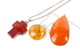 Three amber pendants. One of pale colour with inclusions, diameter circa 2.