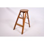 A vintage folding wooden stool. Having a circular top and two steps, H60cm.