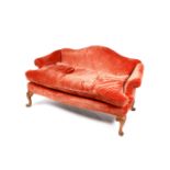 A vintage camel back two seater sofa with burnt orange upholstery.