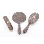 A three-piece silver mounted dressing table set.