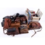 A collection of vintage film cameras and a quantity of books related to photography.