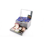A jewellery box full of costume jewellery and badges.
