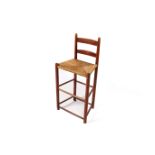 A wooden ladder back bar stool. Having rush seat, raised onturned supports with double stretchers.