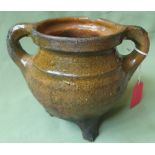 A Medieval glazed pottery cooking pot - some restoration to base and legs, 5.5" high.