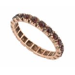 A 9 ct gold garnet set eternity ring. Size L/M.