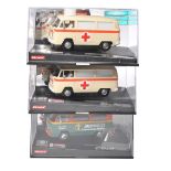 A group of three Carrera slot car models, each a VW Bus T2b in display cases. Two finished as