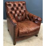 A modern brown buttoned leather upholstered armchair on square splayed legs,