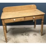 A Victorian pine two drawer side table with added raised back on turned tapering front legs to peg
