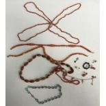 A small leather travelling jewellery box and contents of three pink coral bead necklaces,