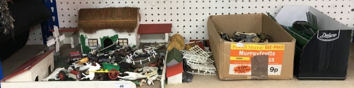 A scratch-built toy farmyard scene with thatched cottage and outbuildings,