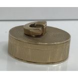 A Cartier 9 carat gold pill box with reeded decoration and D shaped handle to the cover (bears