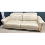 An Ercol "Modica Grande" cream leather upholstered sofa on beech show frame supports,
