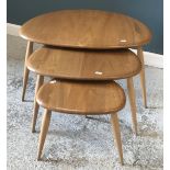 An Ercol elm nest of three pebble occasional tables, largest 65.