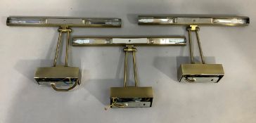 A set of three modern picture wall lights with adjustable arm in brushed brass finish