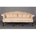 A GEORGE III MAHOGANY CAMEL BACK SETTEE, with scrolled arms, upholstered in apricot fabric, seat