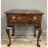 A reproduction walnut lowboy having one large drawer above two smaller side drawers and on
