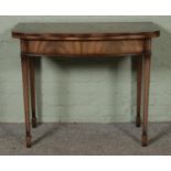 A reproduction mahogany fold over card/game table. Hx77cm, Wx92cm, Dx46cm.
