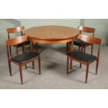 A mid-century G-Plan 'Fresco' circular extending dining table, with four G-Plan dining chairs.