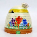 Clarice Cliff, a bee hive honey pot with painted crocus pattern decoration, surmounted by a bee, 9.