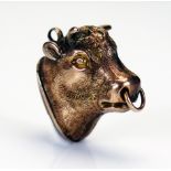 A 19th century bull's mask fob seal in precious yellow metal with an unengraved carnelian matrix,