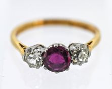 A ruby and diamond three stone ring, set with two old cut diamond, set in 18ct yellow gold, approx