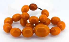 A butterscotch colour amber bead set necklace, set with nineteen beads, approx 88.5g.
