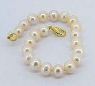 A white cultured pearl bracelet with gold plated clasp, approx 18cm.