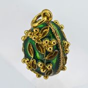 A gold and green enamel egg pendant.
