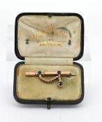 A sapphire and diamond set brooch, set in rose gold, ribbon and drop pattern, in fitted Australian