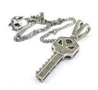 A silver key pendant, pave-set with over 100 white round cubic zirconia, on a silver chain.