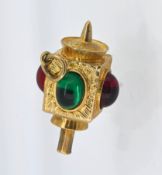 A gold swivel fob/pendant set with green and red stones.
