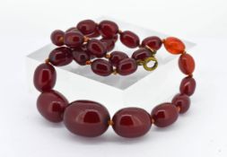 A set of cherry amber bead necklace, set with twenty nine beads (two not cherry coloured), length