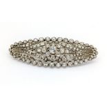 An oval shaped diamond brooch, 59mm wide, 21mm long, set in white metal.