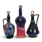 Three Fournier Demars St-Amand flamed glazed stone ware liquor bottles, Gin, Sherry and Brandy,