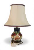 Moorcroft 'Anna Lily Patterned Lamp on cream ground designed by Nicola Slaney. presented on a wooden