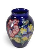 A Moorcroft ovoid shaped Vase Hibiscus pattern on royal blue ground designed by Walter Moorcroft.