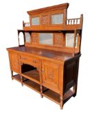 A late Victorian carved oak sideboard with fruit & floral vase panels, the back with long shelf on