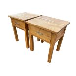 A pair of modern oak bedside tables, each with single drawers, raised on square column legs. (19in x