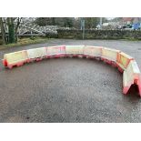 A set of eight lego-style crowd barrier type rectangular interlocking blocks forming a dwarf wall,