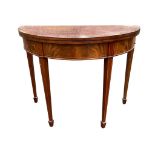 A nineteenth century D-shaped mahogany turn-over-top tea table inlaid with boxwood stringing, the