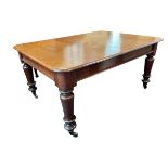 A Victorian mahogany extending dining table with two spare leaves, the rectangular top above a