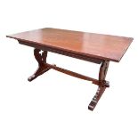 An oak dining table with rectangular top and moulded apron raised on pierced vase shaped trestle