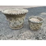 A flared composition stone garden urn with ropetwist rim and tapering latticework body; and