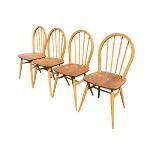 A set of four Ercol beech & elm hooped spindleback chairs with solid shaped seats raised on turned