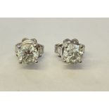 A pair of 18ct gold solitaire diamond stud earrings, the round brilliant cut claw set stones