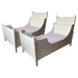 A pair of painted single beds, with pyramidal topped square cornerposts, having headboards with